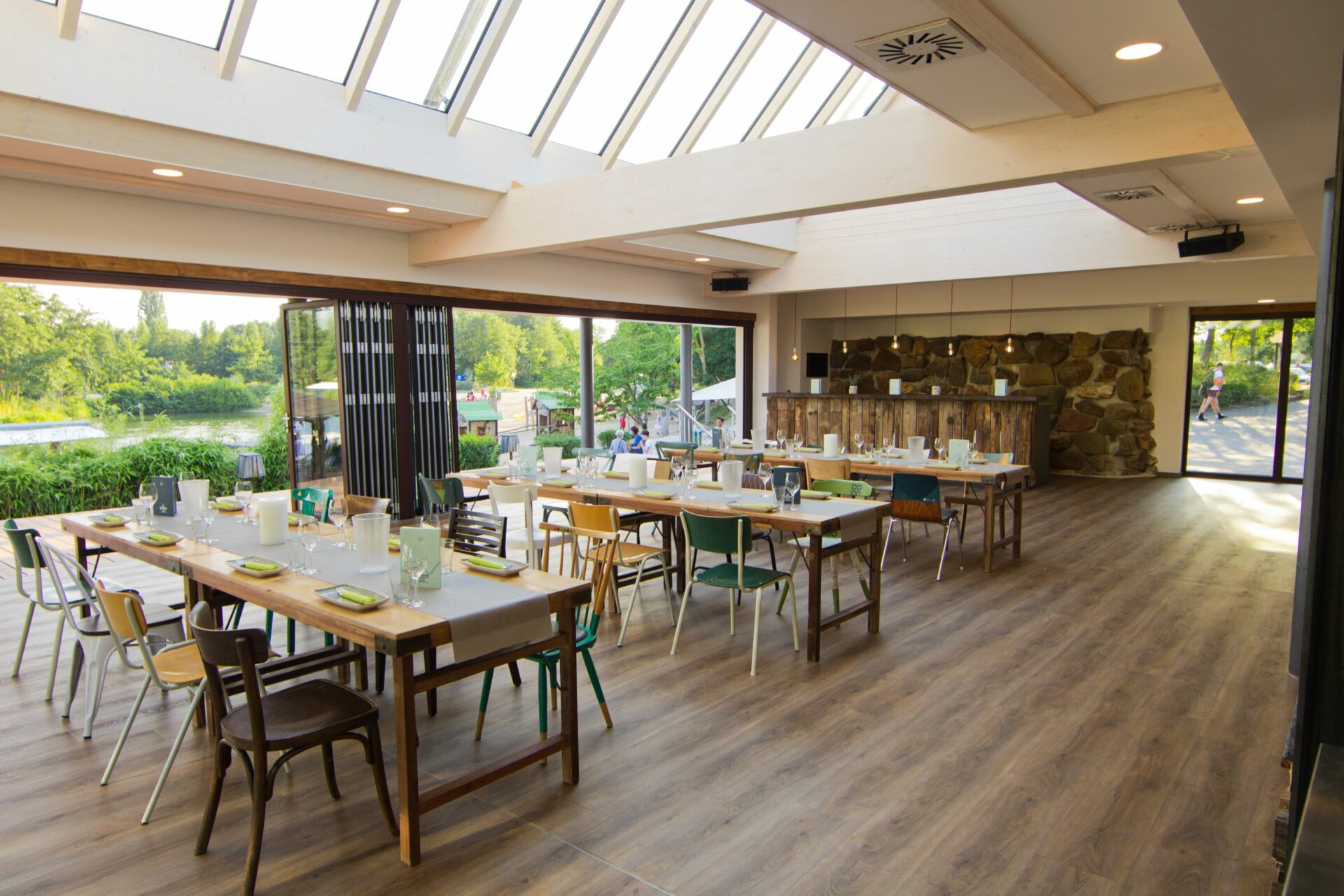 Blick in den Eventraum im Sommer mit drei eingedeckten Tafeln