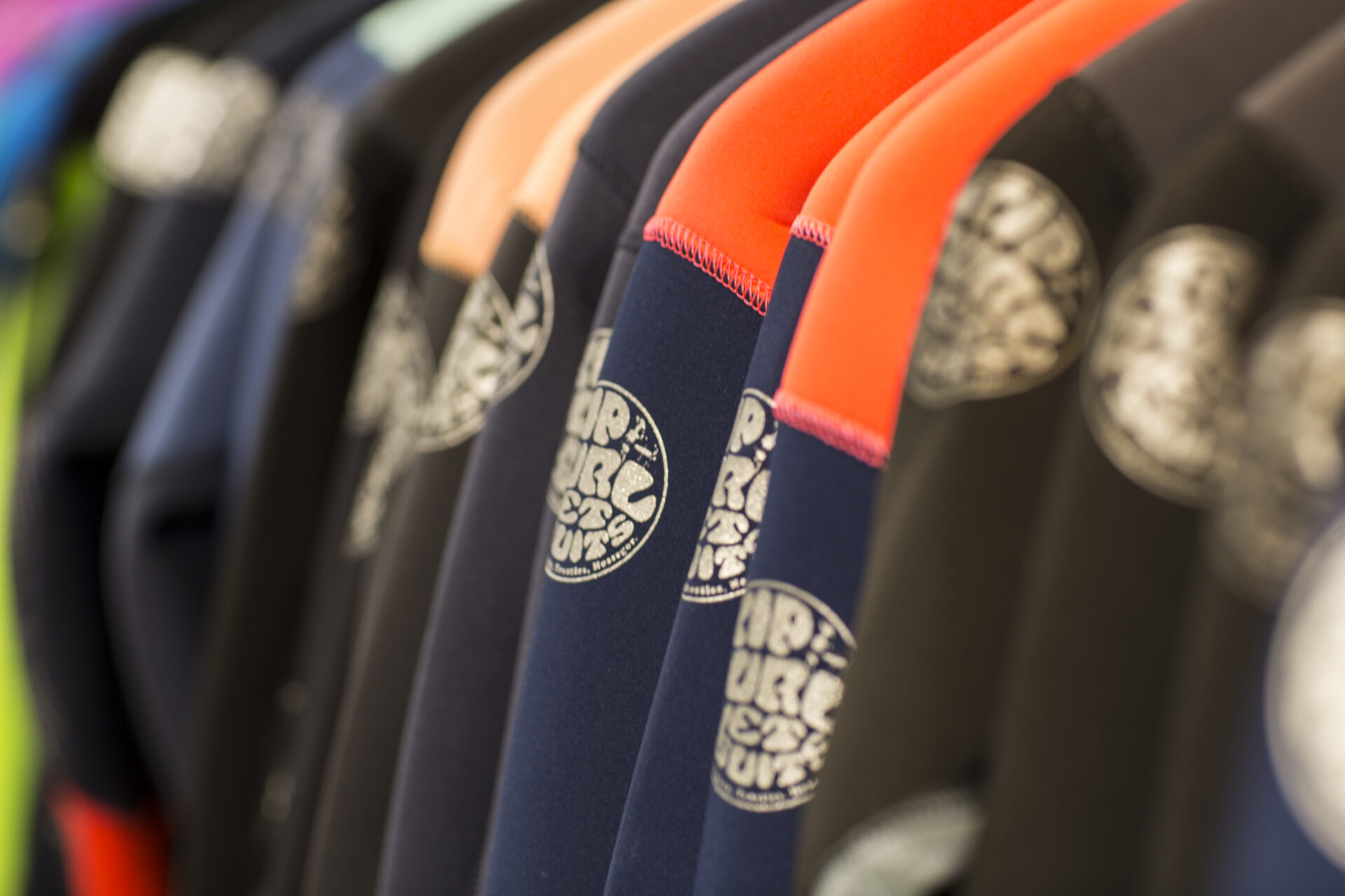 Nahaufnahme verschiedener, bunter Rip Curl Neoprenanzüge