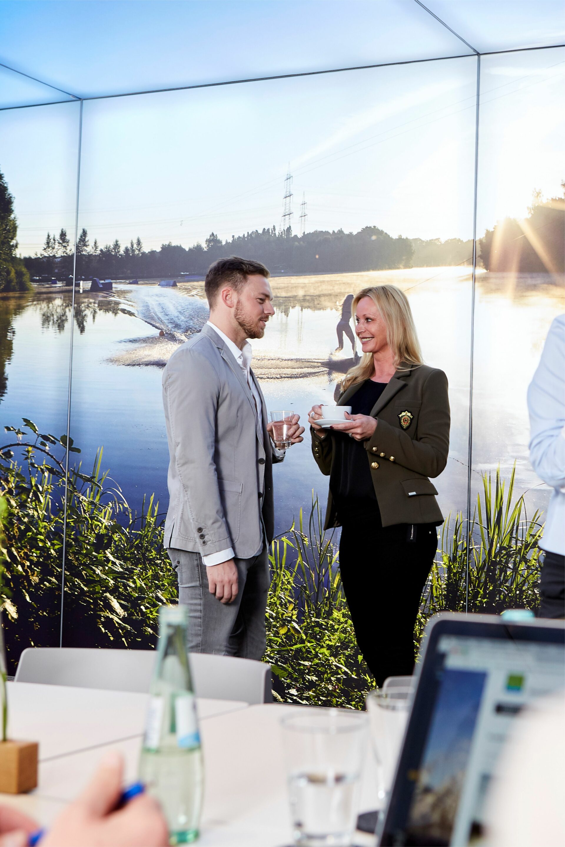seehaus-langenfeld-tagung-brainstorming Geschäftsmann und -frau im Tagungsraum im Gespräch mit jeweils einem Getränk
