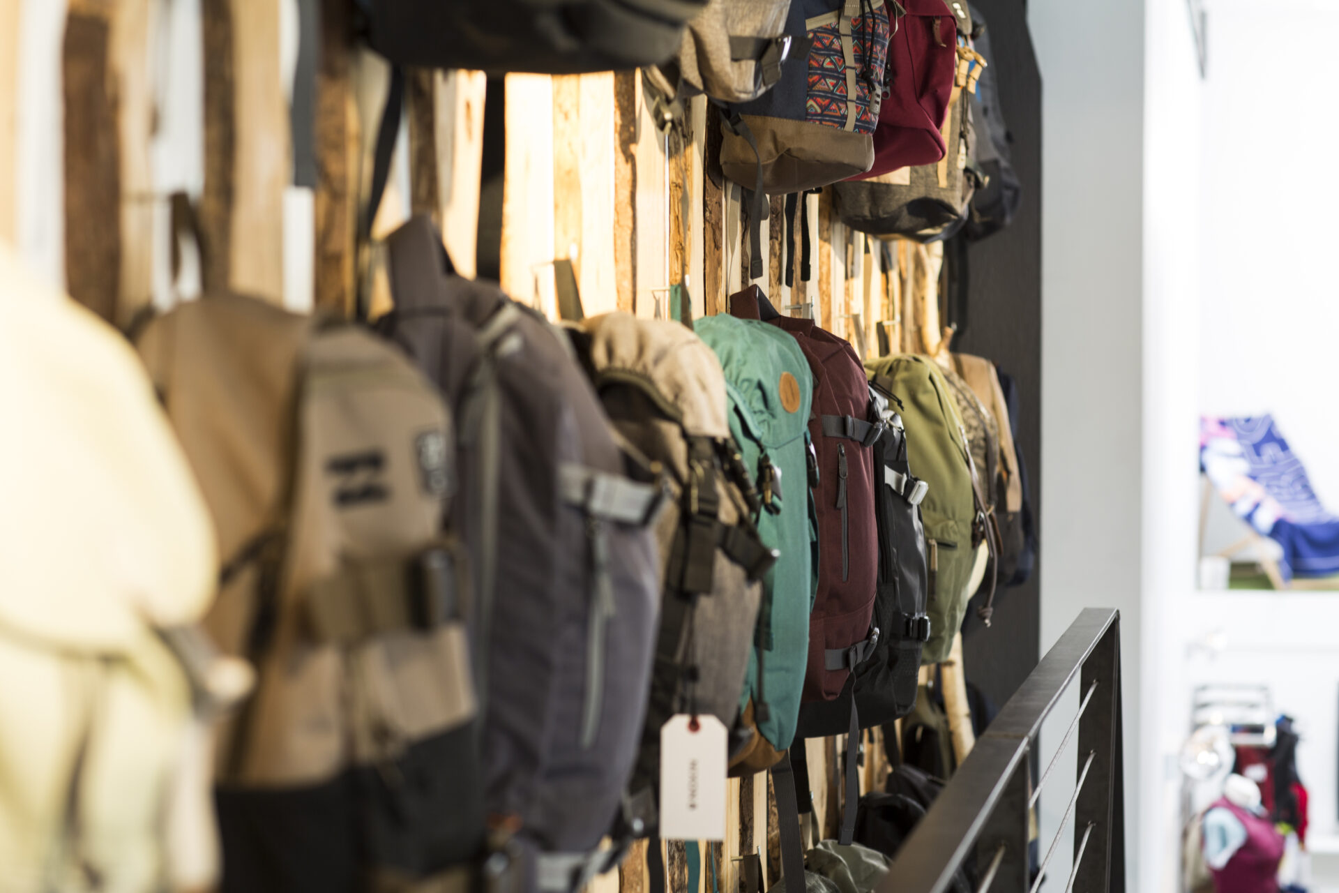 Verschiedene Rucksäcke vor einer Holzwand im Wasserski Langenfeld Shop