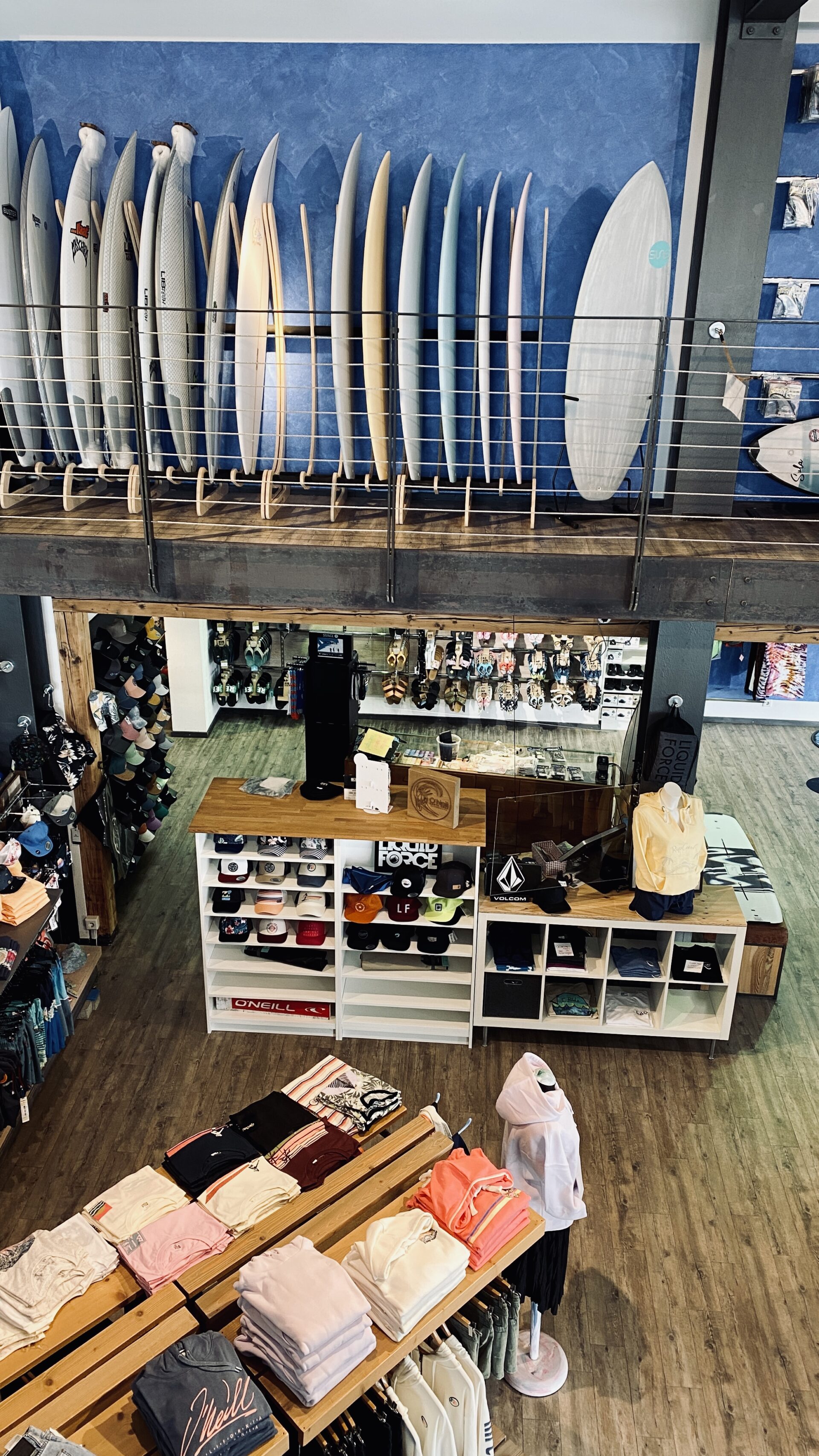 Surfboard-Gallerie im Wasserski Langenfeld Shop mit Blick auf Textil-Regale in der unteren Etage