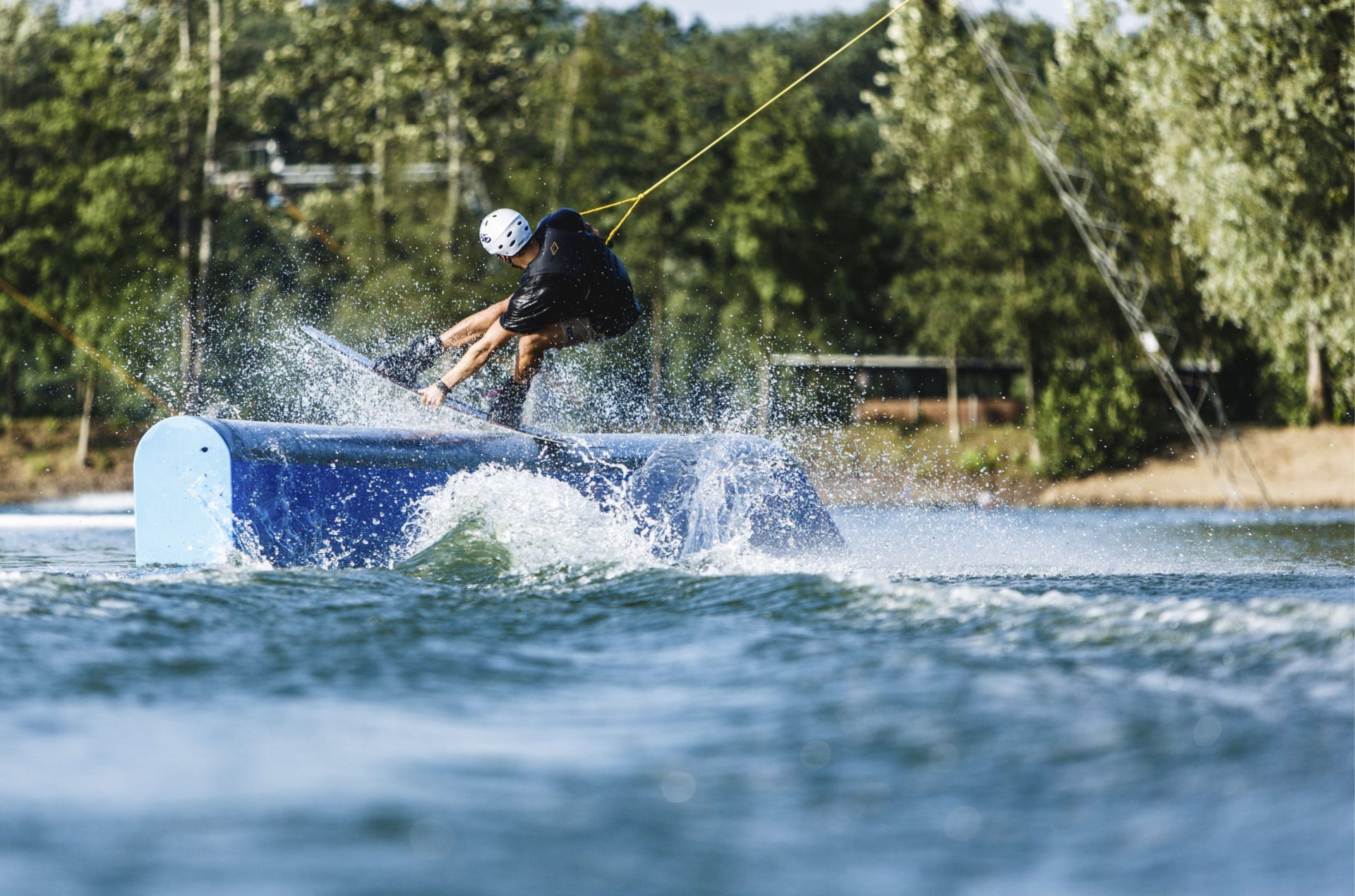 Wakeboarder macht einen frontboard indie über das Pro Rail