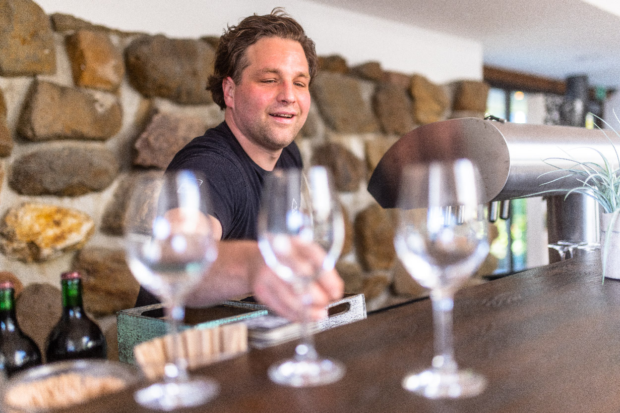 Barmitarbeiter stellt glücklich ein Weinglas auf die Theke